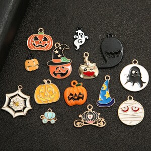 May include: Assortment of Halloween themed metal charms, including pumpkins, ghosts, witches hats, spiders, and a carriage. The charms are gold-toned and have colorful enamel details.