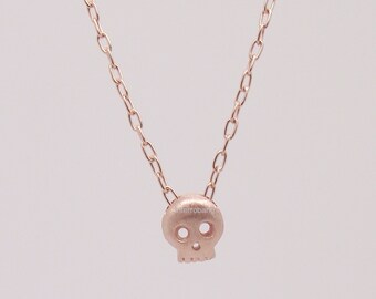 Goth candy skull charm pendant in strawberry glaze on matching chain, sterling silver plated in rose gold