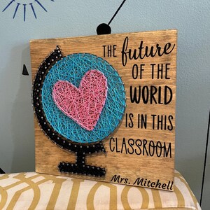 May include: Wooden sign with a string art globe and the text "THE future OF THE WORLD IS IN THIS CLASSROOM Mrs. Mitchell"