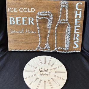May include: Wooden sign with the text "ICE COLD BEER Served Here" and "CHEERS". The beer bottle and glass are outlined with white string. A round wooden coaster with the text "Nailed It by Lyndsay K" and nail illustrations.