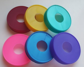May include: Six colorful plastic rings with a hole in the center. The rings are in the colors red, yellow, teal, pink, blue, and purple.