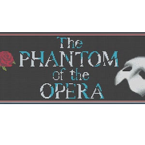 Op de afbeelding: Een zwart-wit kruissteekpatroon met de tekst "The Phantom of the Opera" in wit met blauwe accenten. Een rode roos en een wit masker zijn ook in het ontwerp opgenomen.