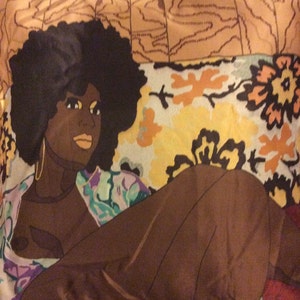 Puede incluir: Una tela colorida con una ilustraci&oacute;n en blanco y negro de una mujer con un peinado afro. La mujer lleva un vestido estampado y est&aacute; tumbada sobre la tela. La tela tiene un patr&oacute;n floral con colores amarillos, naranjas y marrones.