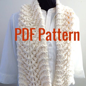 May include: A white knitted scarf with a lacy pattern. The scarf is draped over a white shirt and the text "PDF Pattern" is superimposed on the image.