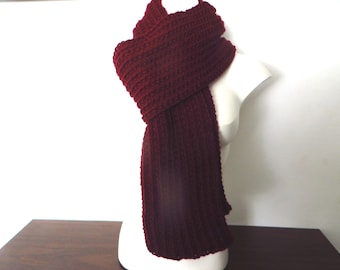 May include: A burgundy knitted scarf with a ribbed texture. The scarf is draped over a white mannequin.
