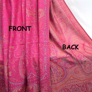 May include: A bright pink shawl featuring an intricate woven paisley pattern in shades of gold and purple. The image displays both sides of the fabric, labeled with the text FRONT on the left and BACK on the right, showing the color variation.