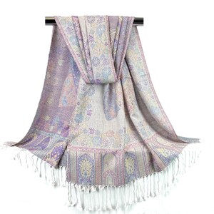 May include: A purple, pink, and cream patterned pashmina scarf with white fringe. The scarf is draped over a silver rod.