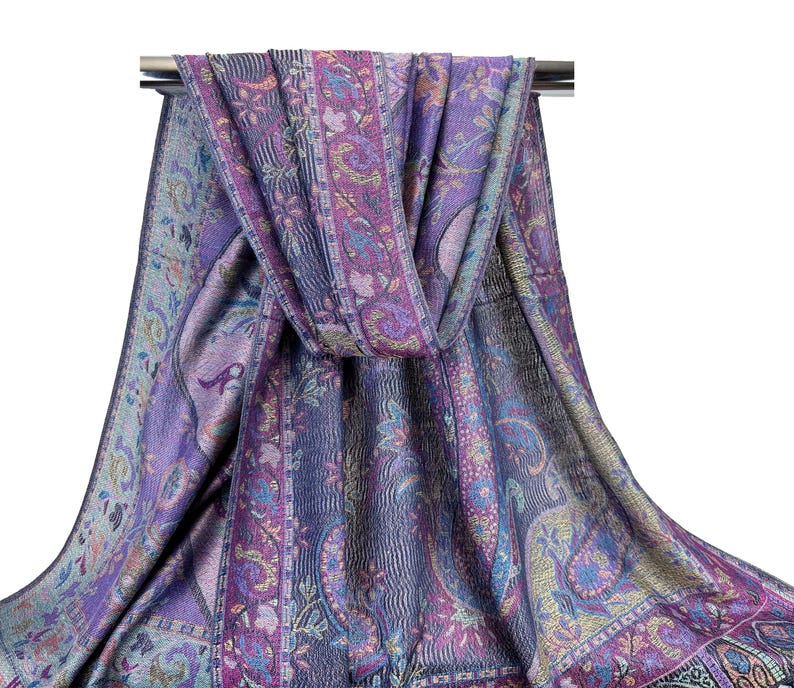 May include: A purple and blue paisley patterned scarf with gold accents. The scarf is folded and draped over a silver rod.