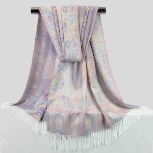 May include: A soft, purple and white paisley patterned scarf with white fringe. The scarf is draped over a metal rod.
