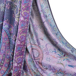 May include: A purple and blue paisley patterned shawl with a fringed edge. The shawl is made of a soft, lightweight fabric and is perfect for adding a touch of elegance to any outfit.
