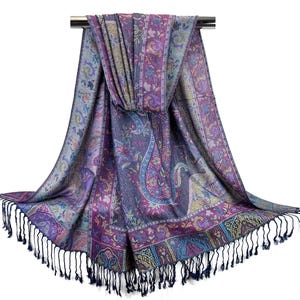 May include: A purple, blue, and gold paisley patterned scarf with fringe. The scarf is draped over a silver rod.