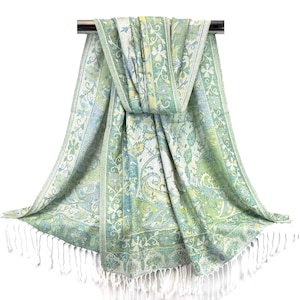 May include: A green and white paisley patterned scarf with white fringe. The scarf is draped over a silver rod.