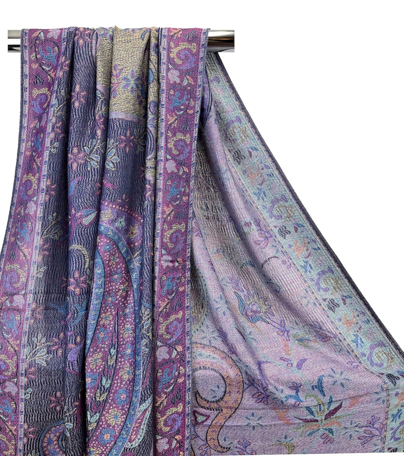 May include: A purple and blue paisley patterned shawl with a gold and pink border. The shawl is draped over a hanger.
