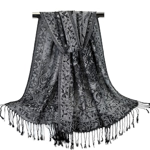 May include: A black and silver patterned shawl with fringe. The shawl is made of a soft, lightweight fabric and is perfect for adding a touch of elegance to any outfit.