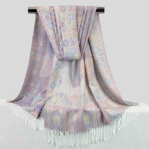 May include: A soft, purple and white patterned scarf with a fringed edge. The scarf is made of a lightweight fabric and is perfect for adding a touch of elegance to any outfit.