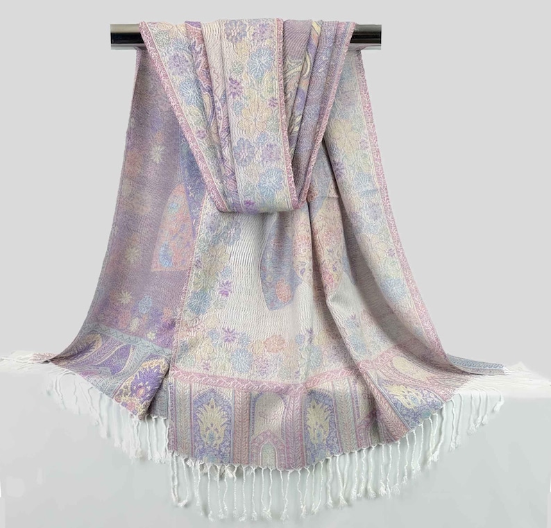 May include: A soft, purple and white patterned scarf with a fringed edge. The scarf is made of a lightweight fabric and is perfect for adding a touch of elegance to any outfit.