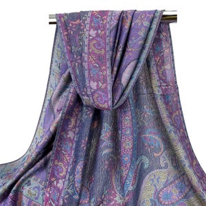 May include: A purple and blue paisley patterned scarf with a fringed edge. The scarf is draped over a silver rod.