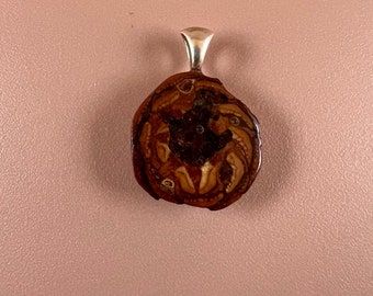 Pinecone pendant with garnet inlay.