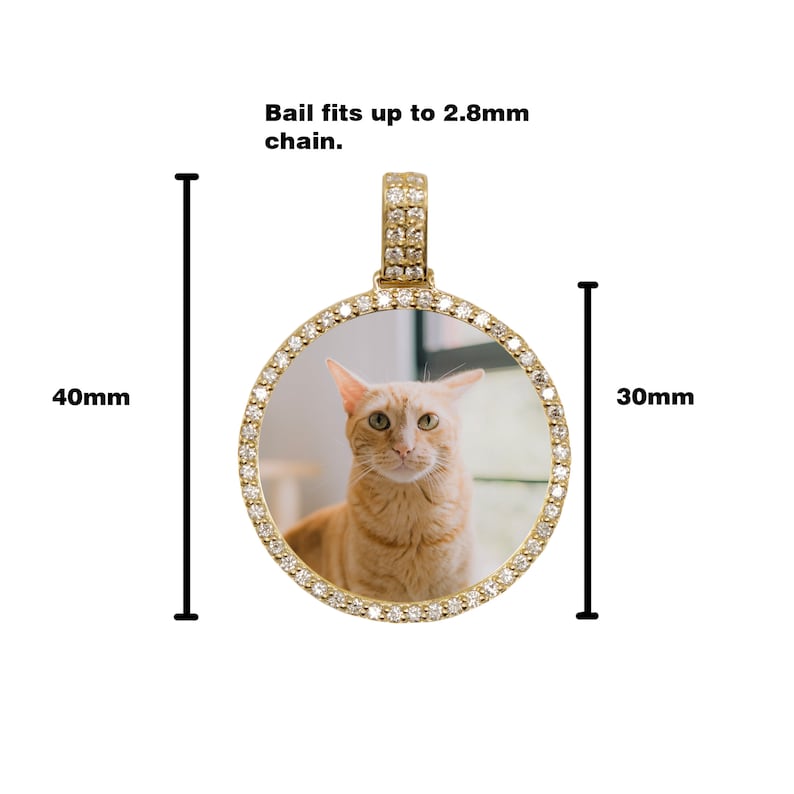May include: Gold-tone round photo locket pendant with a clear glass insert and a diamond-like crystal border. The locket is 40mm in height and 30mm in width. The bail fits up to a 2.8mm chain.
