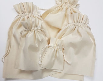 May include: Set of four natural cotton drawstring bags in various sizes. The bags are made of a soft, natural fabric and have a simple, elegant design.