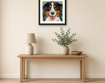 May include: A framed square art print featuring a collage-style illustration of a Bernese Mountain Dog with black, white, and brown fur, a pink tongue, and brown eyes, set against a muted green background within a black frame.