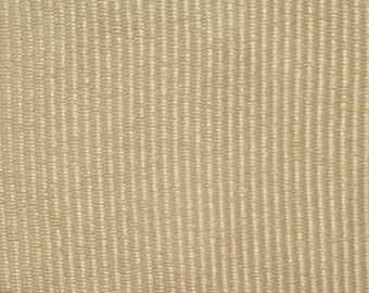 May include: A close-up of a beige fabric with a subtle, textured pattern. The fabric has a slightly shiny finish.