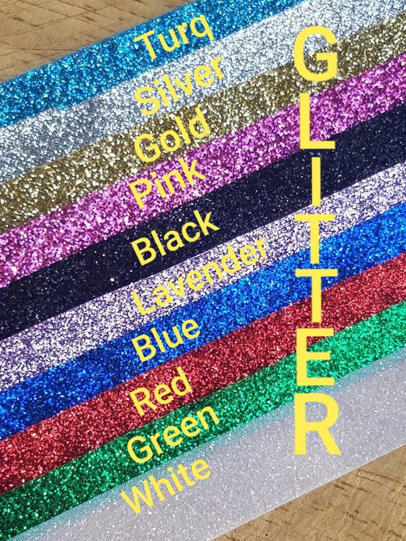 May include: A close-up of a variety of glitter colors, including turquoise, silver, gold, pink, black, lavender, blue, red, green, and white. The word "GLITTER" is written vertically in yellow letters.