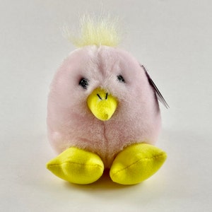 May include: A pink and yellow plush chick toy with a yellow beak and black eyes.