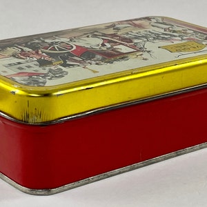 May include: A red and gold tin box with a vintage illustration of a horse-drawn carriage and the text "24 Gold" on the lid.