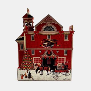 May include: A red wooden Christmas ornament depicting a firehouse with a decorated Christmas tree, a horse-drawn fire engine, and two children playing in the snow. The firehouse has a bell tower and a sign that reads "Protection."