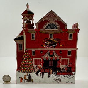 May include: A red wooden Christmas ornament depicting a firehouse with a Christmas tree, a horse-drawn carriage, and the text "Protection".