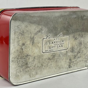 May include: Red and yellow metal tin with a silver lid. The lid has the text "Fletcher & Pollack N.Y.C. Bake-In Trade Mark Gift Can Pat. Pend."