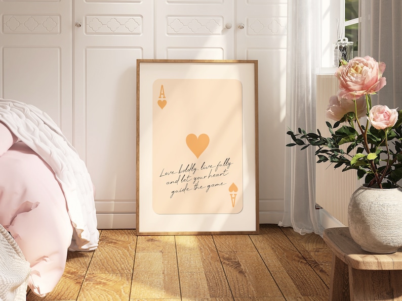 May include: A printable poster featuring a stylized illustration of an ace of hearts playing card with the text "Love boldly, live fully and let your heart guide the game." The background is a light peach color.