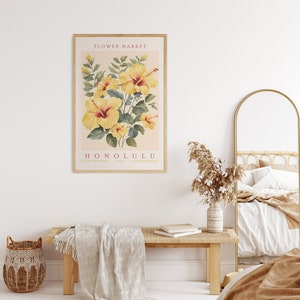 May include: A framed print with a vintage botanical illustration of yellow hibiscus flowers. The print has the text "FLOWER MARKET HONOLULU" in red.