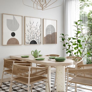 Puede incluir: Una mesa de comedor con seis sillas, una tetera y cuatro platos. La mesa es de madera y tiene un acabado marr&oacute;n claro. Las sillas son de mimbre tejido y tienen un acabado natural. Las paredes son blancas y presentan tres estampados geom&eacute;tricos abstractos en negro, blanco y marr&oacute;n. Una planta con hojas verdes est&aacute; en la esquina de la habitaci&oacute;n.