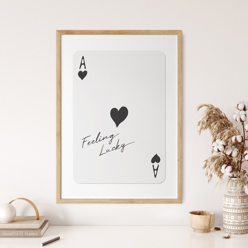 May include: A framed print of an ace of spades playing card with a black heart and the text "Feeling Lucky" in cursive.
