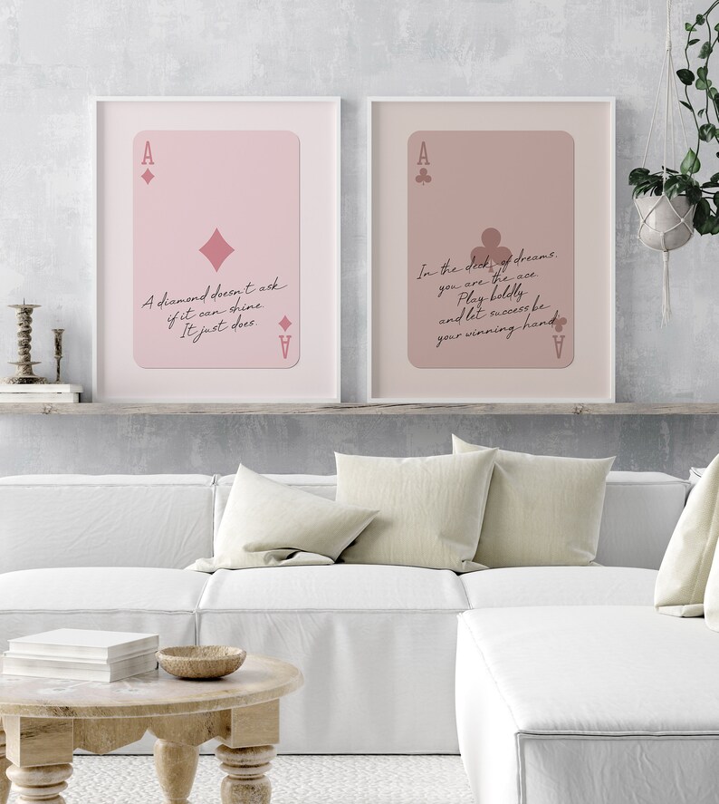 May include: Two printable art prints with pink backgrounds and white frames. The prints feature a playing card ace of diamonds and ace of clubs with inspirational quotes. The first print says "A diamond doesn't ask if it can shine. It just does." The second print says "In the deck of dreams, you are the ace. Play boldly and let success be your winning hand."