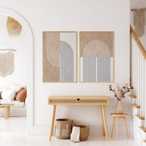 Peut inclure: Deux impressions d'art abstraites encadr&eacute;es avec des motifs g&eacute;om&eacute;triques beiges, noirs et blancs sont accroch&eacute;es au-dessus d'une console en bois clair. Des paniers en osier et un petit tabouret en bois avec un vase de fleurs s&eacute;ch&eacute;es compl&egrave;tent le d&eacute;cor de l'entr&eacute;e.