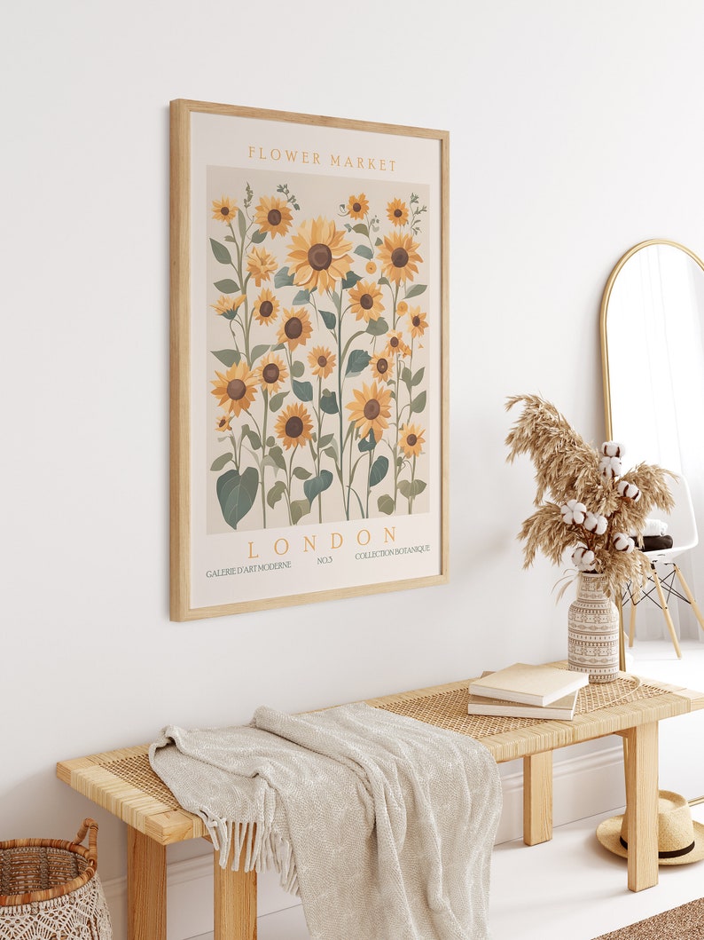 May include: A framed print with a botanical illustration of sunflowers in shades of yellow and green. The print has the text "FLOWER MARKET LONDON NO.3 COLLECTION BOTANIQUE GALERIE D'ART MODERNE" at the bottom.