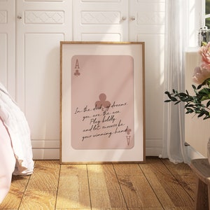 May include: A pink and brown poster with a playing card design. The card is an ace of clubs and has the text "In the deck of dreams, you are the ace. Play boldly and let success be your winning hand."