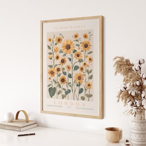 May include: A framed print of a botanical illustration featuring a cluster of sunflowers in shades of yellow and green. The print is titled "Flower Market London" and includes the text "Galerie d'Art Moderne No.3 Collection Botanique".