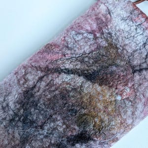 May include: A small, pink, grey, and brown felted bag with a brown leather strap and silver hardware.