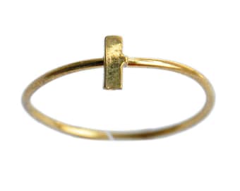 May include: A gold ring with a small, vertical bar design. The ring is simple and delicate.