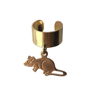 May include: Gold ear cuff with a dangling rat charm. The rat is a stylized silhouette with a detailed face.