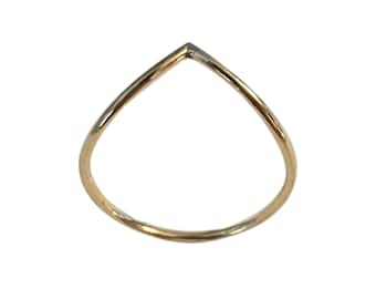 May include: A simple gold ring with a V-shaped design.