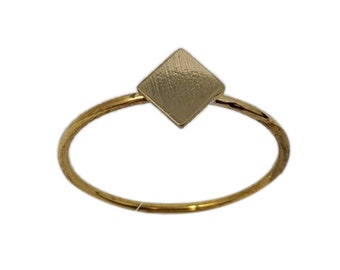 May include: A gold ring with a square-shaped, brushed metal top.
