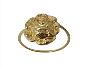 May include: A gold-colored ring with a rose-shaped design. The rose is detailed and has a textured surface.