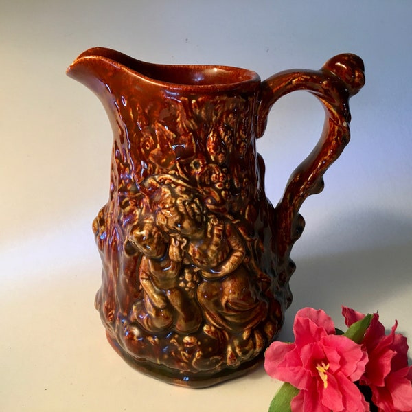 Unique vintage brown ceramic pottery majolica pitcher with harvesters, grapes, leaves and vines carved in tree
