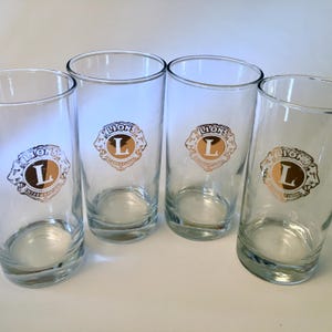 Set of four vintage Lions International glass tumblers with gold logo by Bartlett Collins