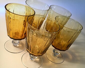 Set of five amber water goblets with clear stem and double wafers